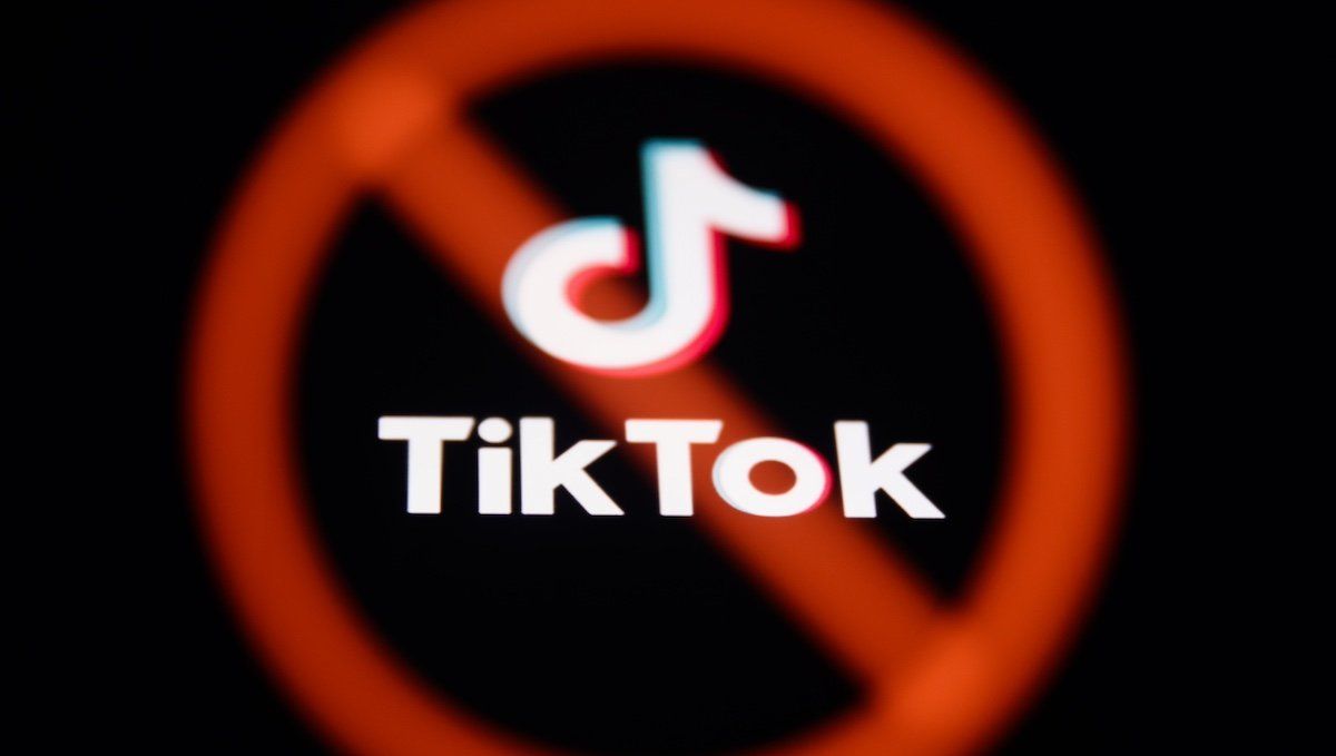 ​A ban sign displayed on a laptop screen and TikTok logo displayed on a phone screen are seen in this multiple exposure illustration photo taken in Poland on March 17, 2024. 