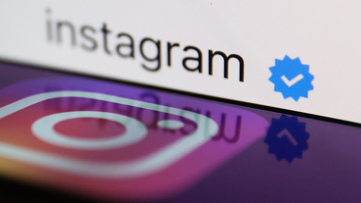 ​A blue verification checkmark on Instagram account on Instagram displayed on a laptop screen and Instagram logo displayed on a phone screen are seen in this illustration photo taken in Poland on February 19, 2023. 