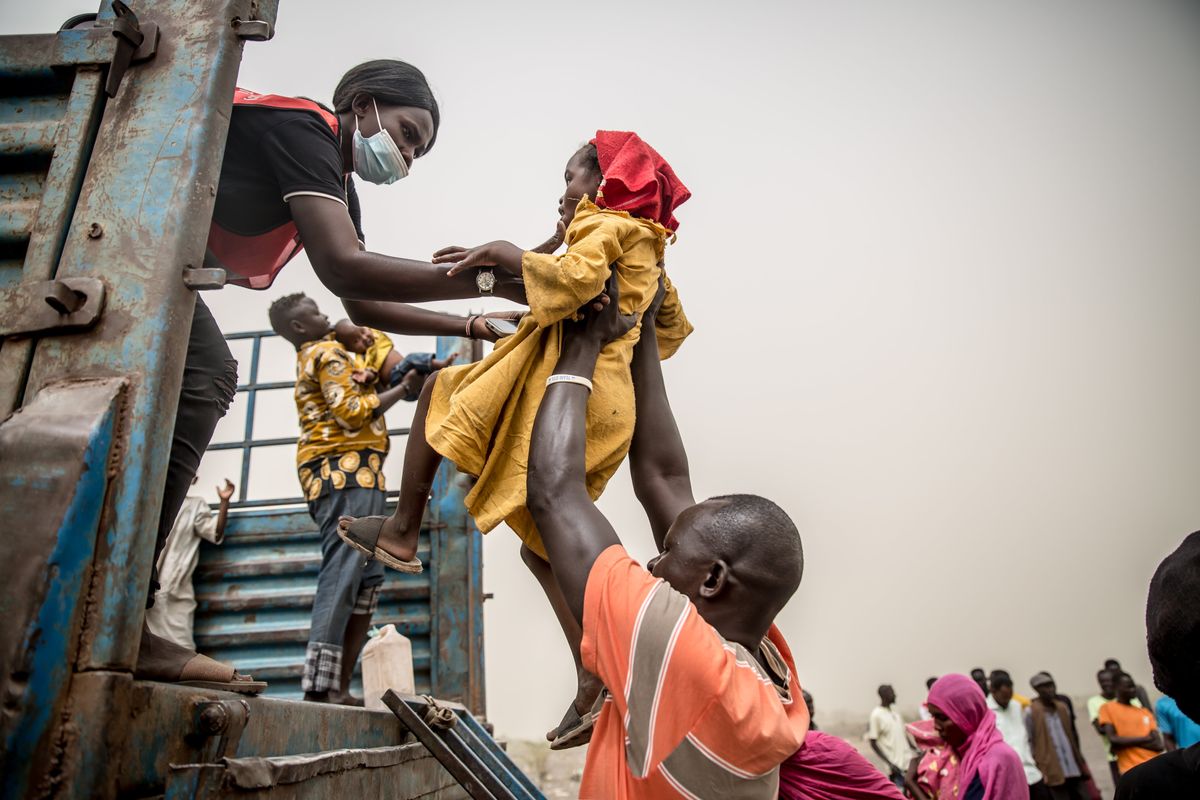 A child is loaded into a truck taking people fleeing Sudan's war from Joda, on the Sudanese border