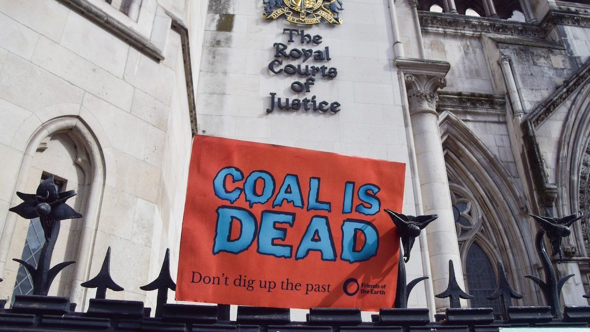 A 'coal is dead' placard is seen during the demonstration. Activists from Friends Of The Earth and other environmental groups gathered outside the Royal Courts of Justice as the legal challenge to the Whitehaven coal mine in Cumbria begins.