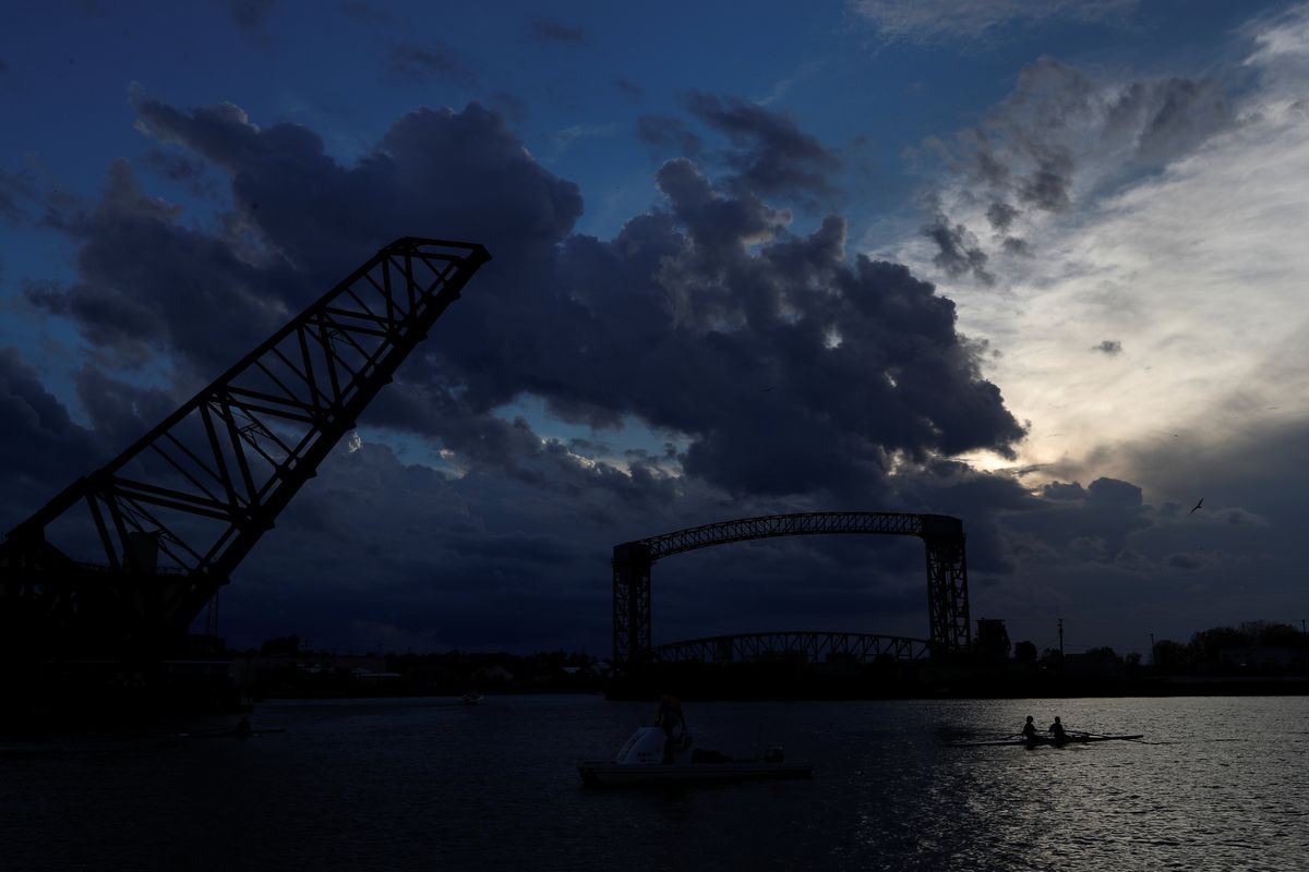 A crew rows along the Cuyahoga river at sunset in the Flats section of Cleveland, Ohio, U.S., October 23, 2020. 