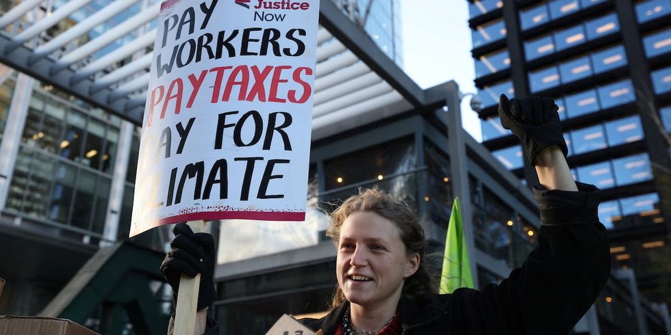 ​A demonstrator holds a placard during a protest outside the Amazon headquarters during Black Friday in London, Britain, November 24, 2023. 