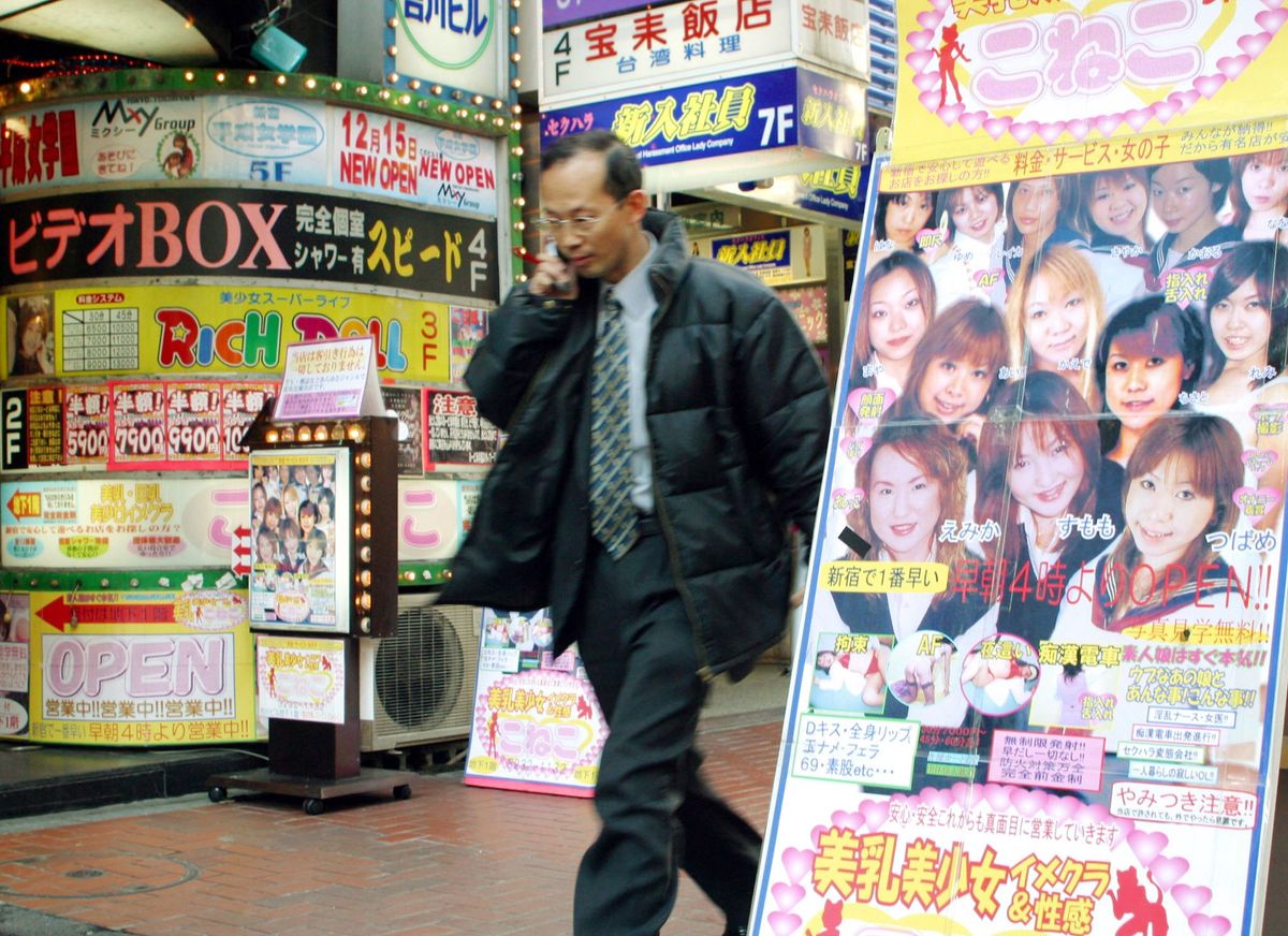 A man walks past advertisements for massage parlours in Tokyo's Kabukicho red-light district 