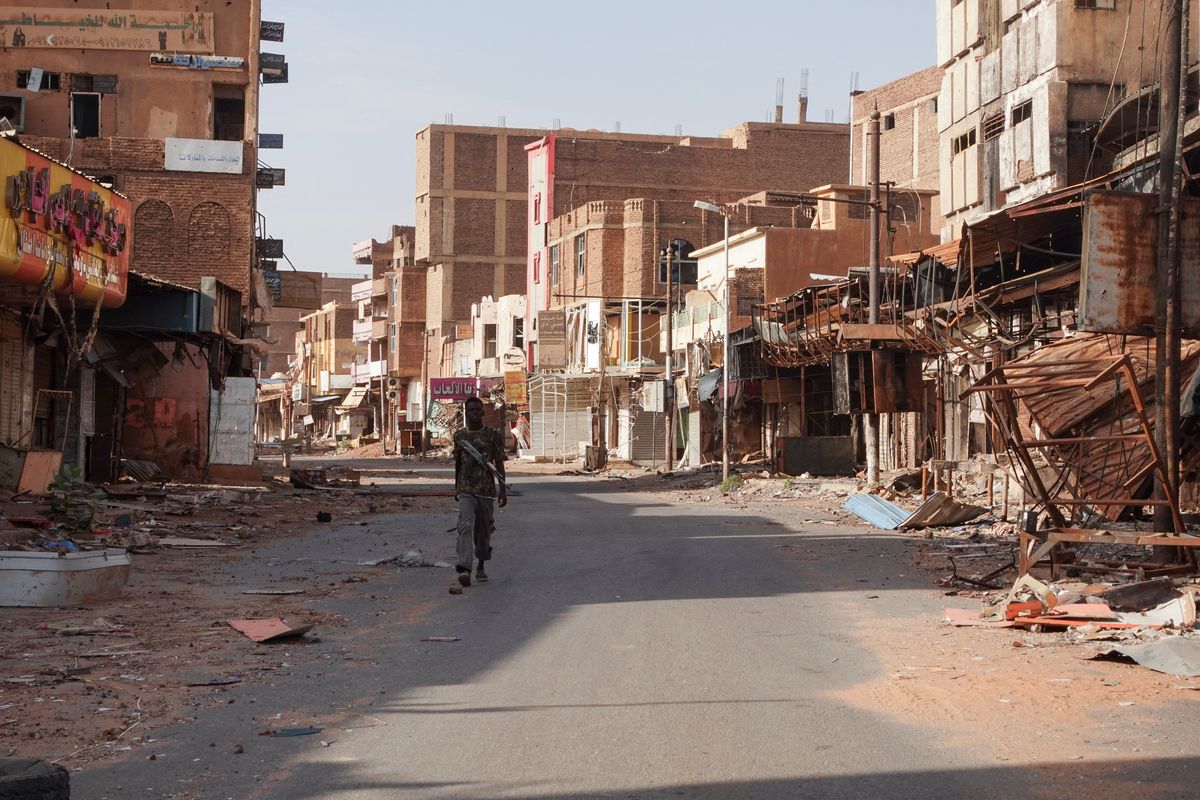 ​A member of the Sudanese Armed forces walks between damaged buildings, almost one year into the war between the Sudanese Armed Forces and the paramilitary Rapid Support Forces (RSF), in Omdurman, Sudan, April 7, 2024. 