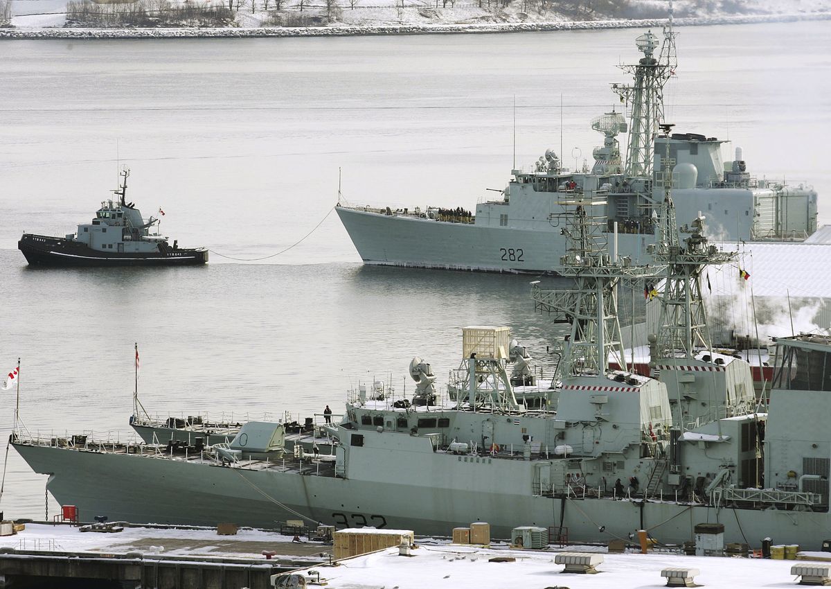 A navy tug pulls the destroyer HMCS Athabascan (top) into its dock at CFB Halifax in Nova Scotia.