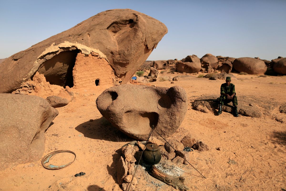 A Polisario fighter sits on a rock at a forward base on the outskirts of Tifariti, Western Sahara, September 9, 2016. 