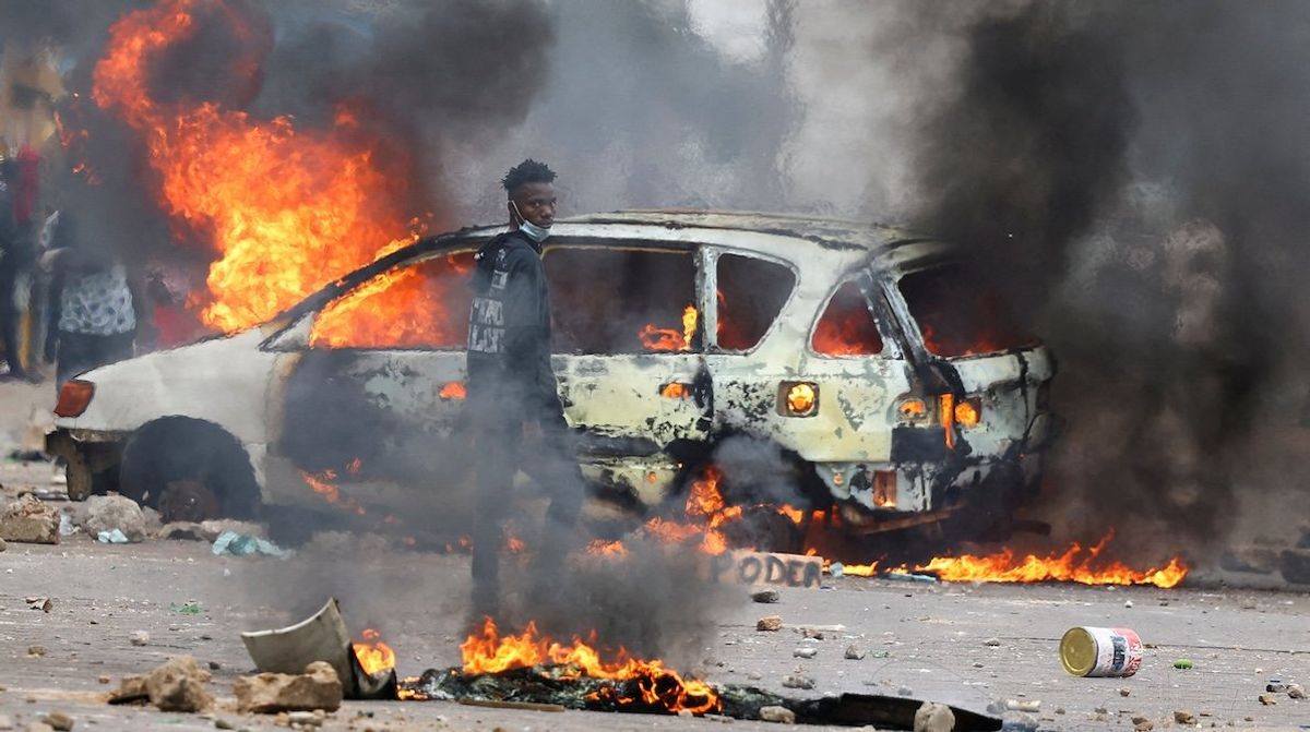 ​A protester looks on near a burning barricade during a "national shutdown" against the election outcome, in Maputo, Mozambique, on Nov. 7, 2024. 