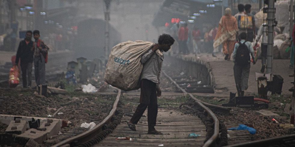 ​A ragpicker searches for garbage as he walks through railway tracks on a smoggy morning in New Delhi, India on November 4, 2023.