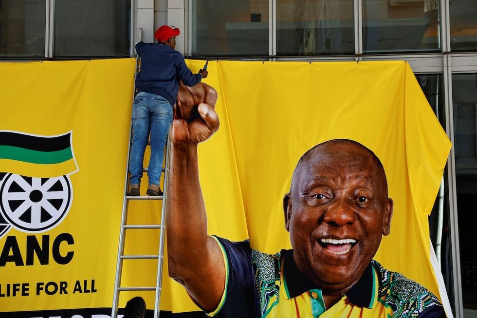 A worker removes a campaign banner of South African president Cyril Ramaphosa after an African National Congress event ahead of the upcoming elections in Sandton, Johannesburg, South Africa, on May 25, 2024. ​