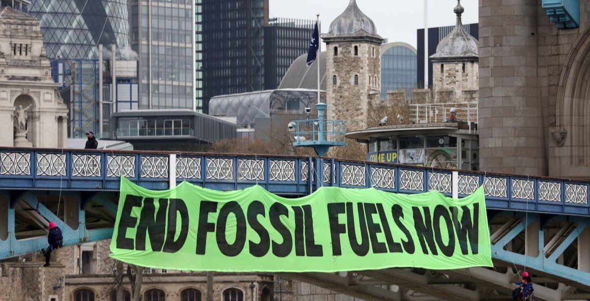 ​Climate change activists hang a sign on Tower Bridge during a demonstration against the climate crisis, in central London, Britain, April 8, 2022. 