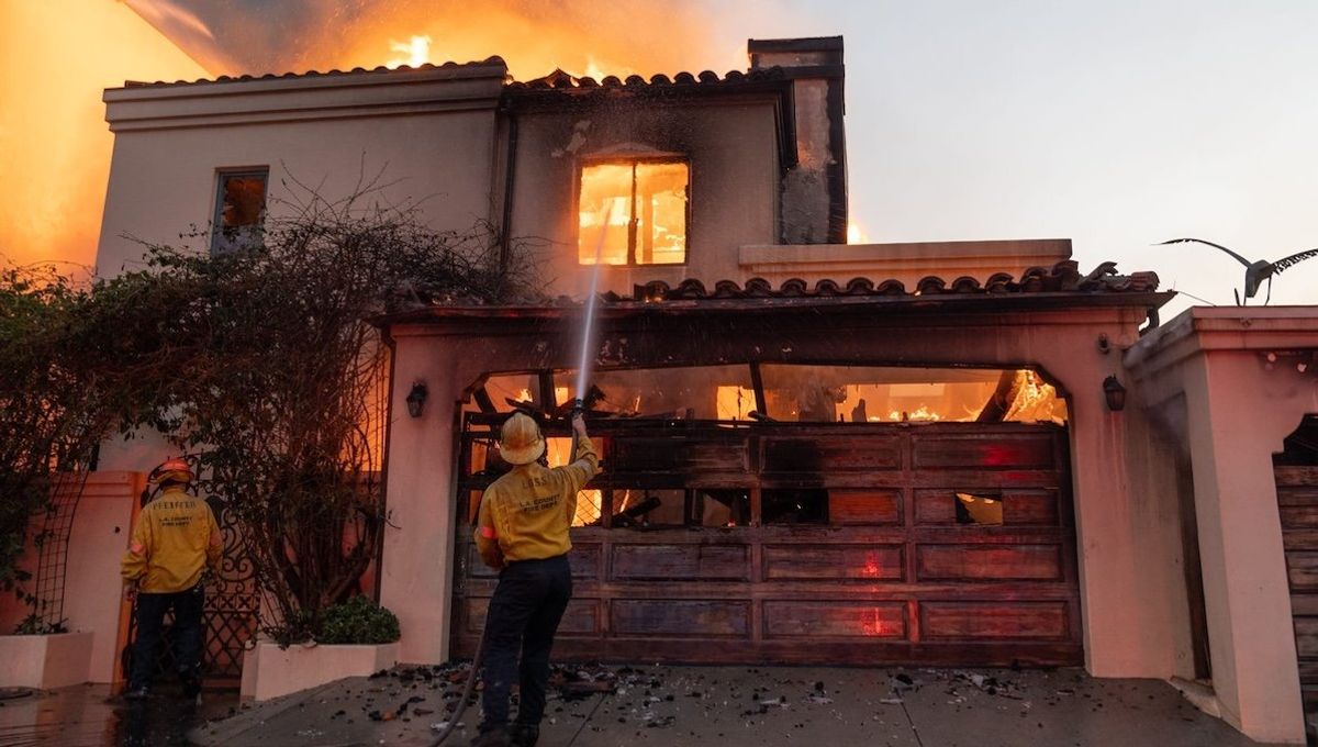 ​Firefighters attempt to extinguish a fire in a home along the Pacific Coast Highway in the Pacific Palisades neighborhood.