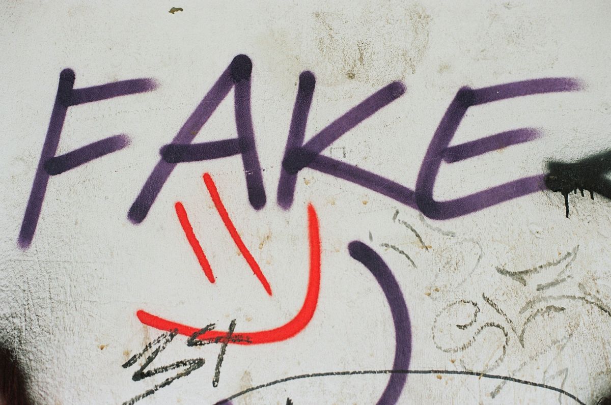 Graffiti on a wall that says "fake."