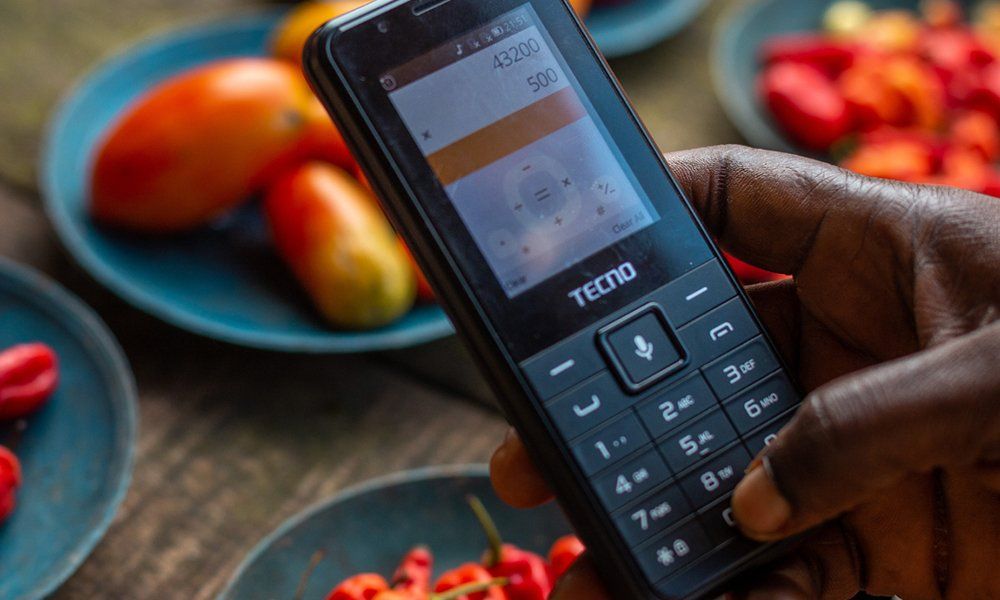 A person using the calculator on an old mobile phone