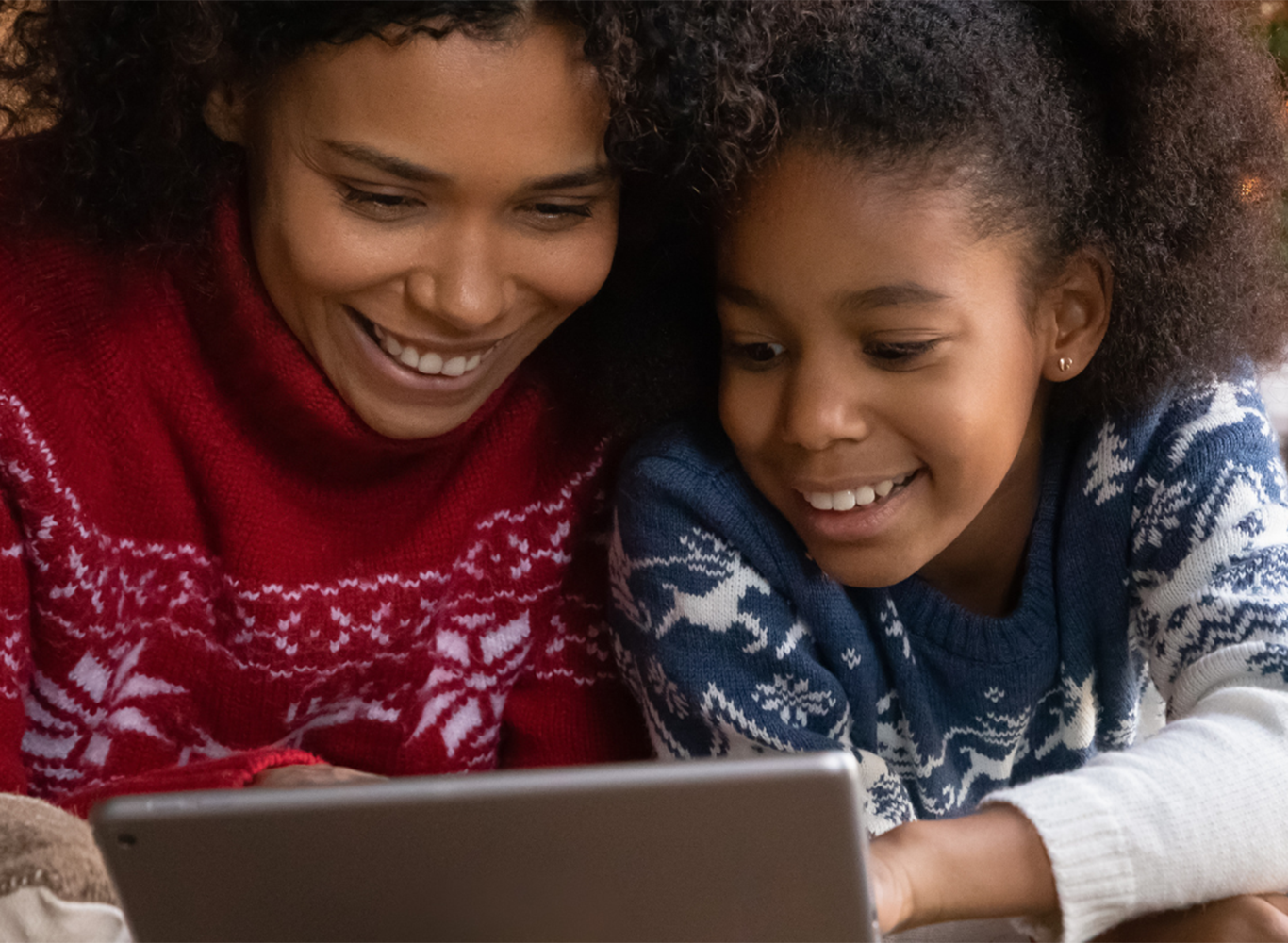 A woman and a pre-teen girl looking at an iPad together