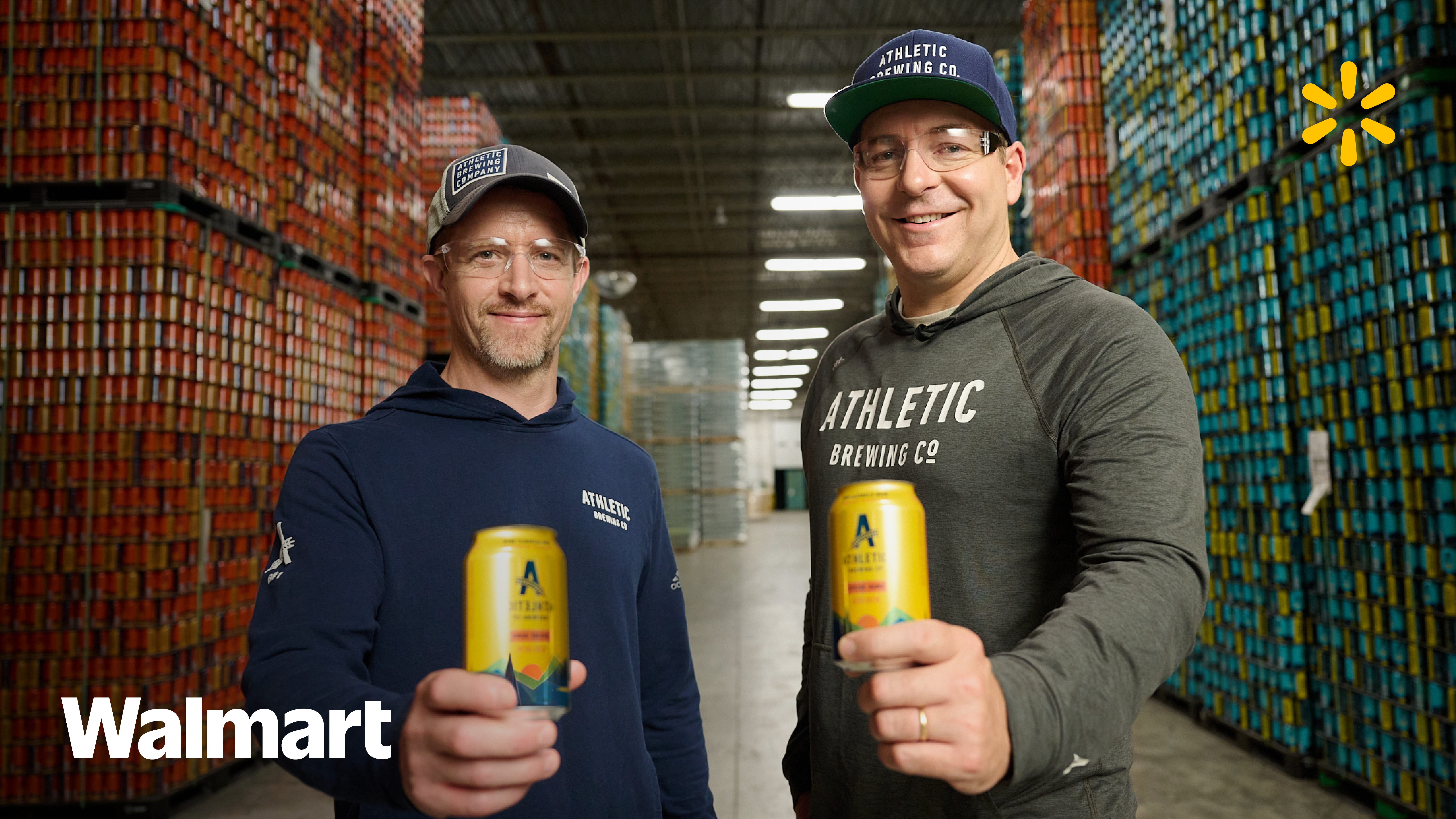 Two guys holding a beer can in a beer warehouse