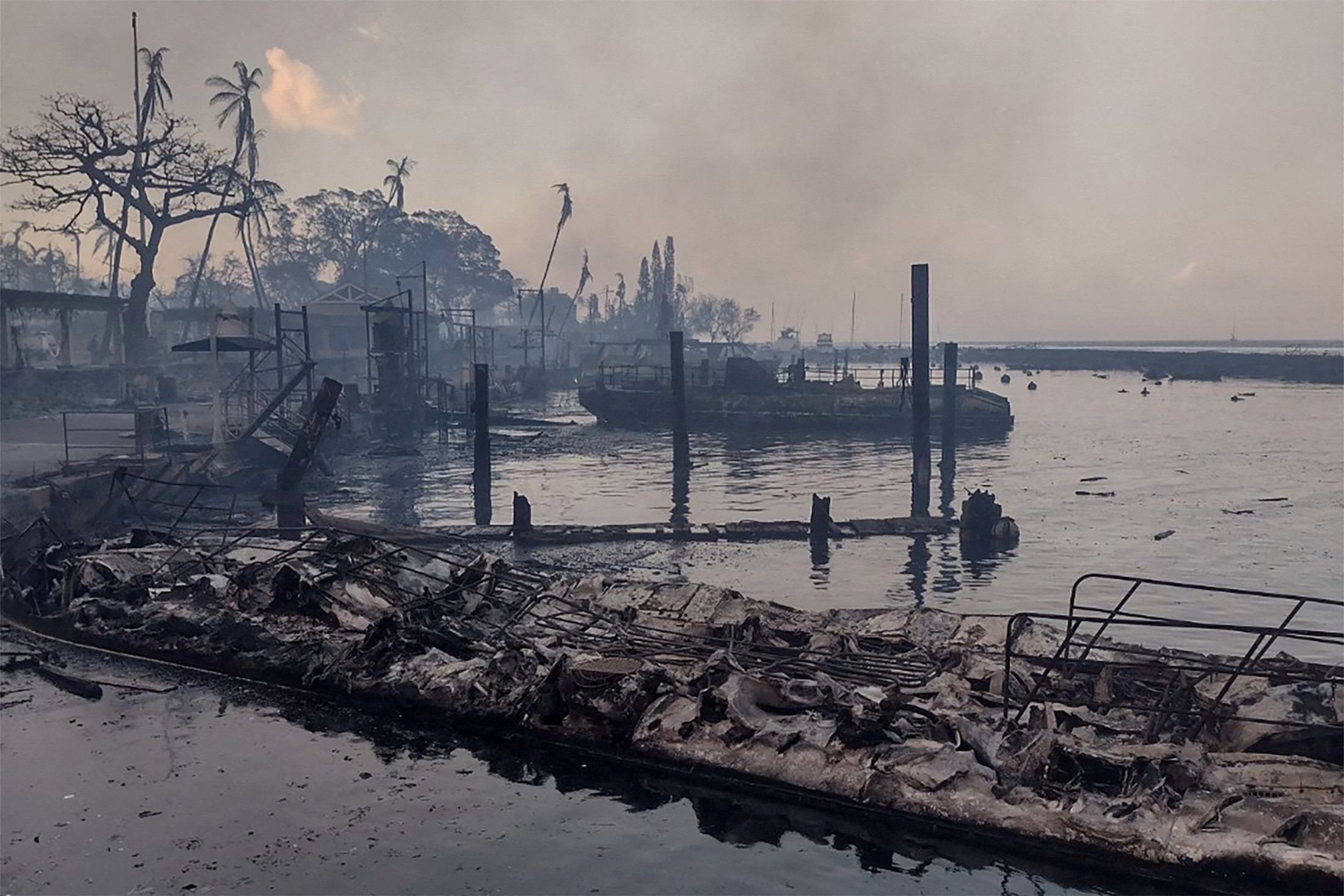 A charred boat lies in the scorched waterfront after wildfires fanned by the winds of a distant hurricane devastated Maui's city of Lahaina, Hawaii.