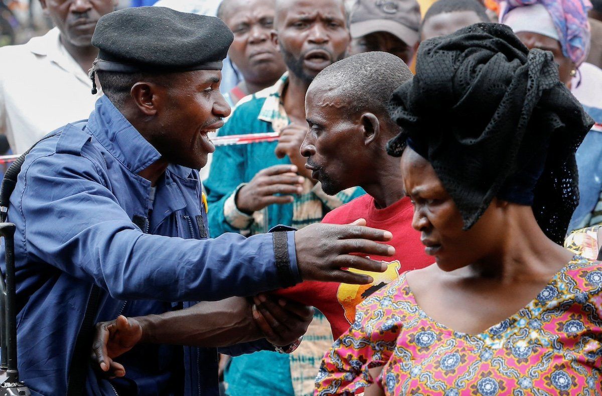 A Congolese police officer controls internally displaced Congolese people before they vote at the Kanyaruchinya polling centre, during the Presidential election, at the Kanyaruchinya site for displaced people, in Nyiragongo territory, near Goma in North Kivu province of the Democratic Republic of Congo December 20, 2023.