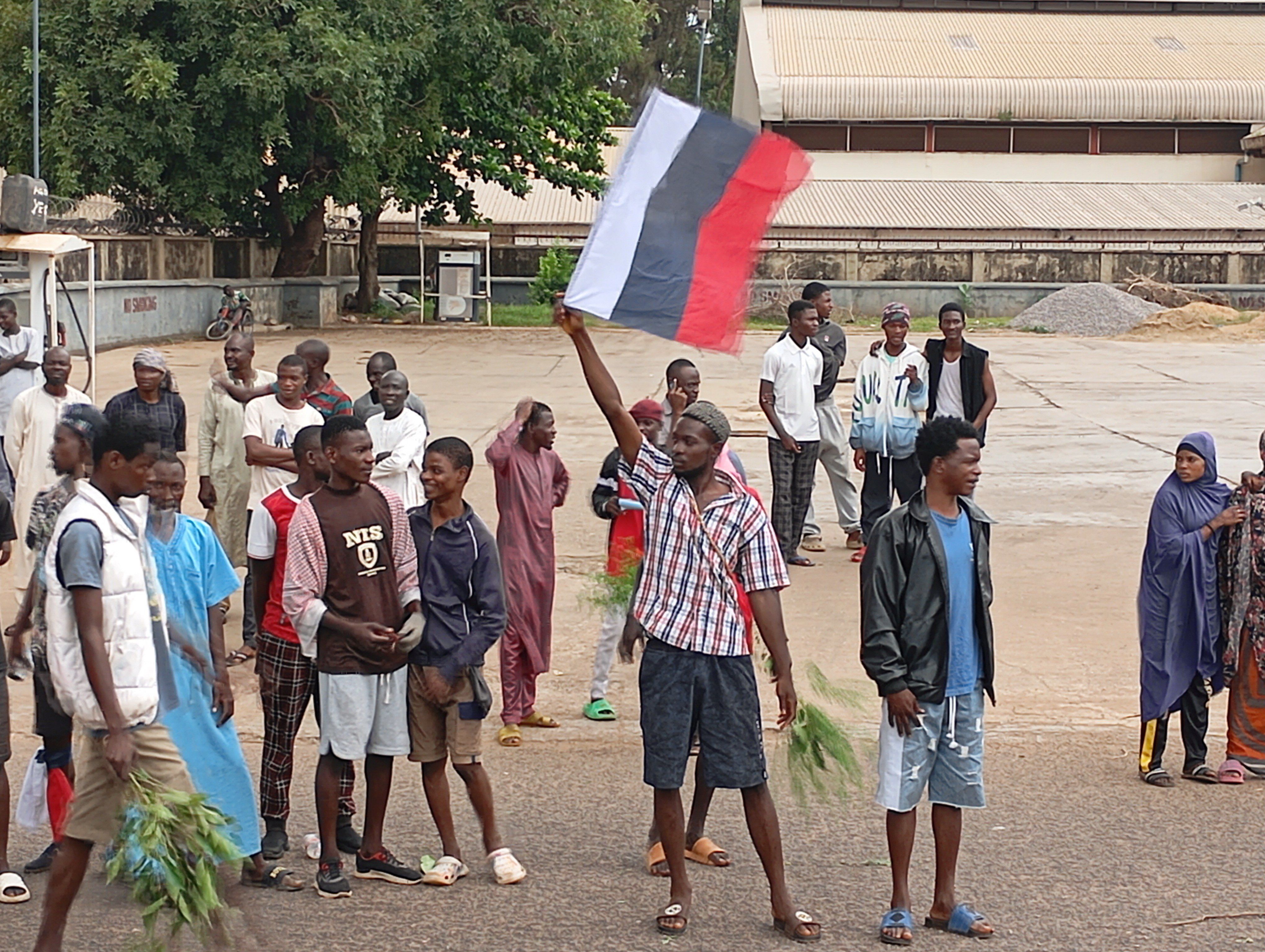 ​A man holds a Russian flag, as Nigerians protest in the streets during anti-government demonstrations against bad governance and economic hardship, in Kaduna state, Nigeria August 5, 2024. 