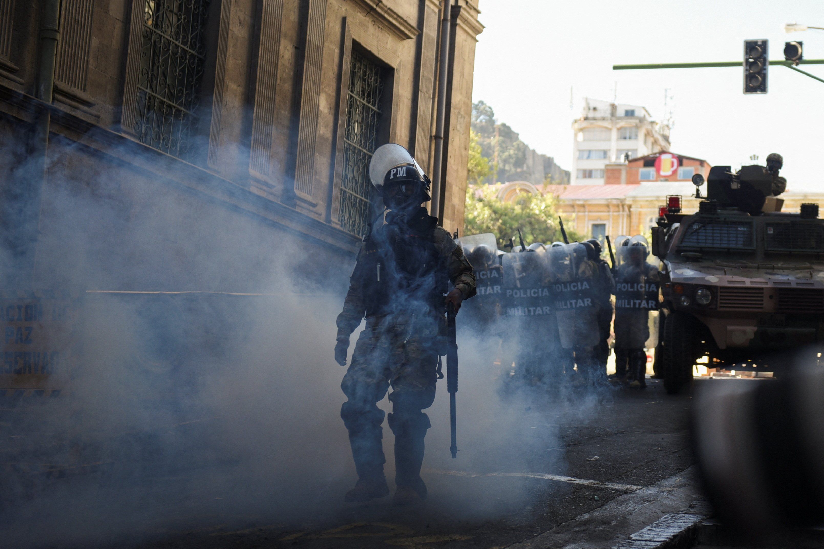 ​A member of the military police walks amid tear gas as Bolivia's President Luis Arce "denounced the irregular mobilization" of some units of the country's army, in La Paz, Bolivia June 26, 2024. 