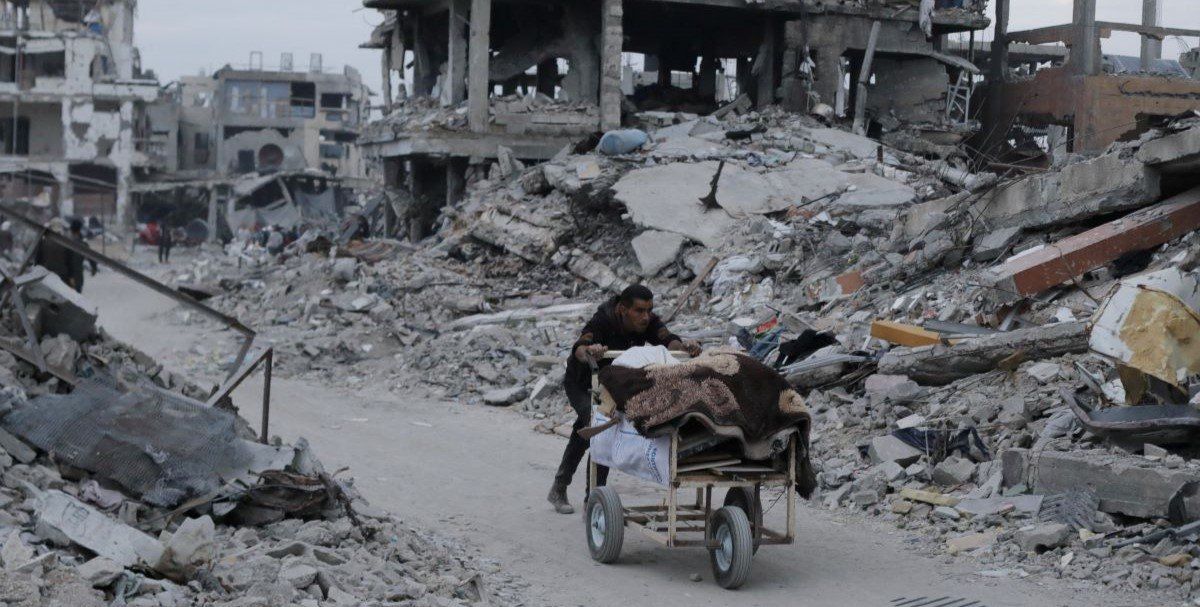 ​A Palestinian pushes belongings past the rubble of buildings and houses destroyed during the Israeli offensive, amid a ceasefire between Israel and Hamas, in Jabalia in the northern Gaza Strip, January 22, 2025. 