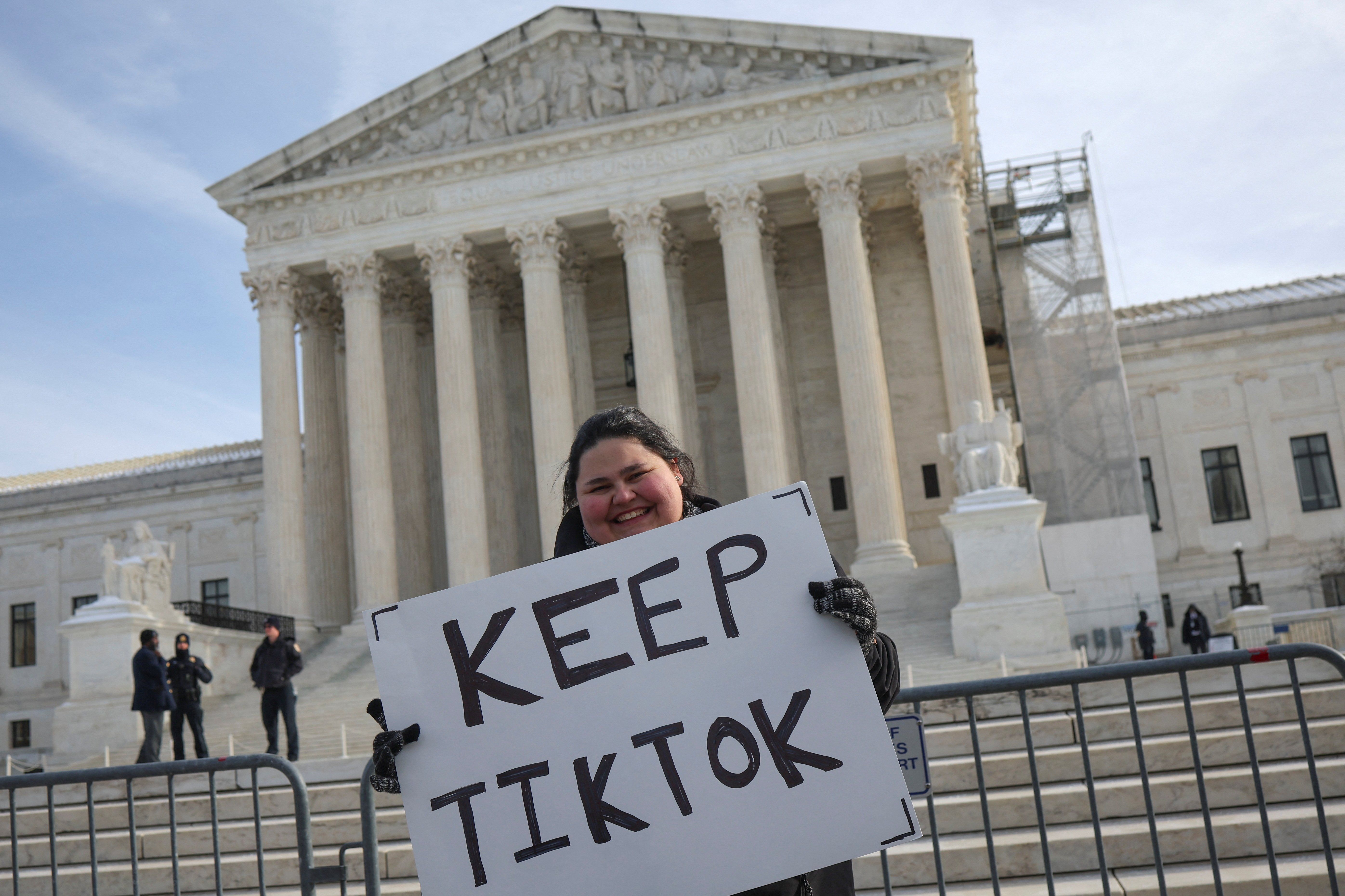 ​A person holds a placard on the day justices hear oral arguments in a bid by TikTok and its China-based parent company, ByteDance, to block a law intended to force the sale of the short-video app by Jan. 19 or face a ban on national security grounds, outside the U.S. Supreme Court, in Washington, U.S., January 10, 2025. 