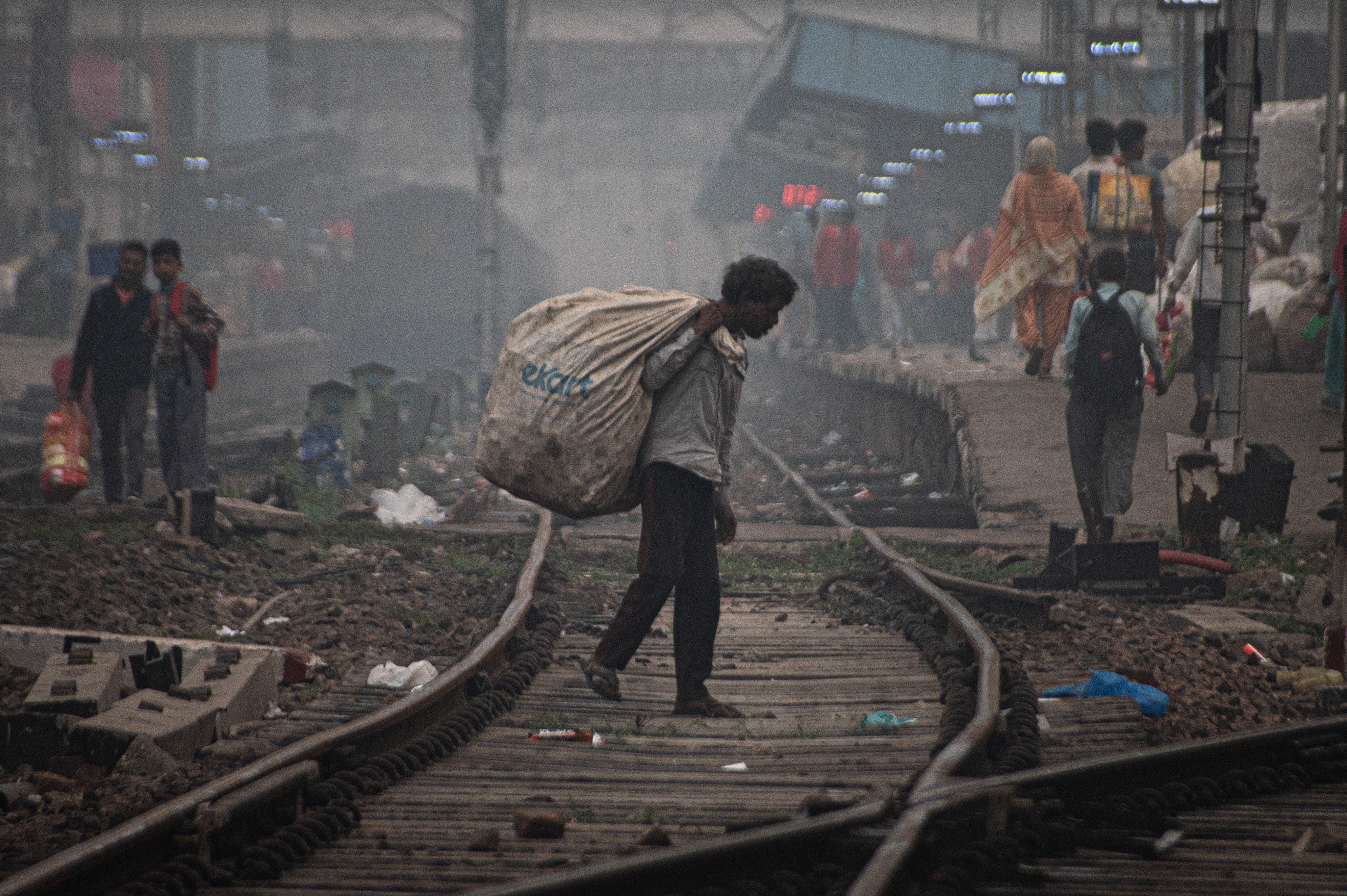 ​A ragpicker searches for garbage as he walks through railway tracks on a smoggy morning in New Delhi, India on November 4, 2023. 