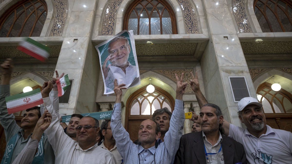 A supporter of Iranian President-elect Masoud Pezeshkian is holding up an electoral poster while participating in a ceremony with Pezeshkian's presence at the Khomeini (Iran's Late Leader) shrine in southern Tehran, Iran, on July 6, 2024. Former reformist Member of Parliament, Masoud Pezeshkian, is being elected as the new President of Iran.