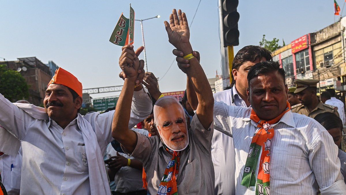 A supporter of the Bharatiya Janata Party (BJP) is wearing a face mask of Indian Prime Minister Narendra Modi and dancing during a roadshow ahead of the Indian General Elections in Ghaziabad, Uttar Pradesh, India, on April 6, 2024.