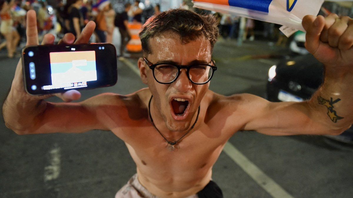 ​A supporter of Uruguay's centre-left presidential candidate Yamandu Orsi celebrates his victory, following early results of the presidential election run-off, along 18 de Julio Avenue in Montevideo, Uruguay November 24, 2024. 