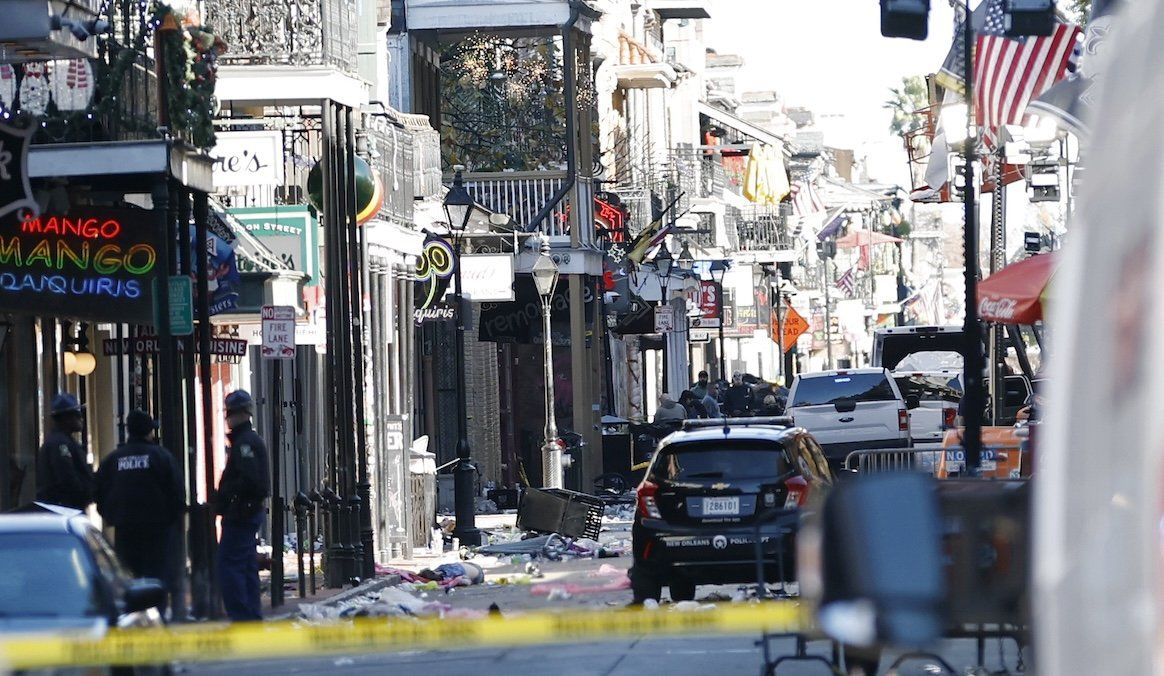 ​A view down Bourbon Street shows a crashed white pickup truck after an apparent attack during New Year's Eve celebrations in New Orleans.