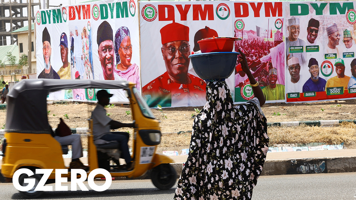 A woman stands in front of electoral campaign posters of Presidential candidate Atiku Abubakar and members of the People's Democratic Party, ahead of Nigeria's Presidential elections, in Yola, Nigeria, February 21, 2023.