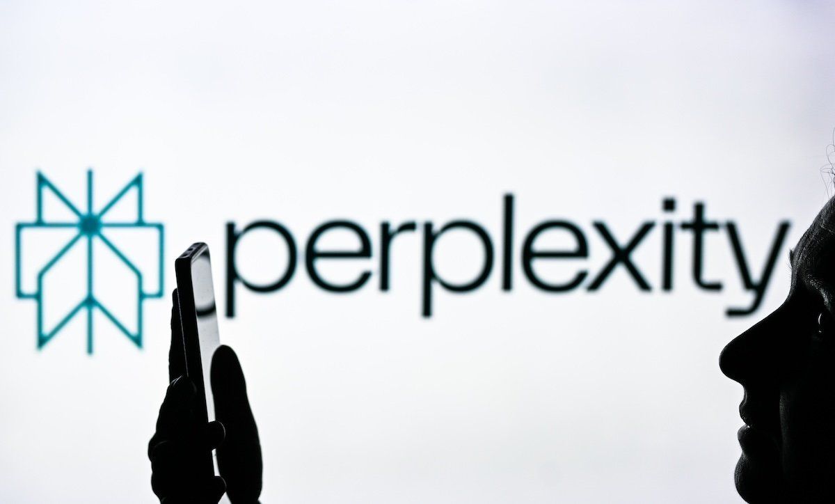 An image of a woman holding a cell phone in front of a Perplexity AI logo displayed on a computer screen.