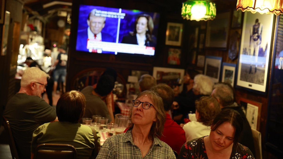 Audience members watch as Republican President Candidate Donald Trump and Democratic Candidate Kamala Harris debate on CNN on September 10, 2024 in Bloomington, Indiana.