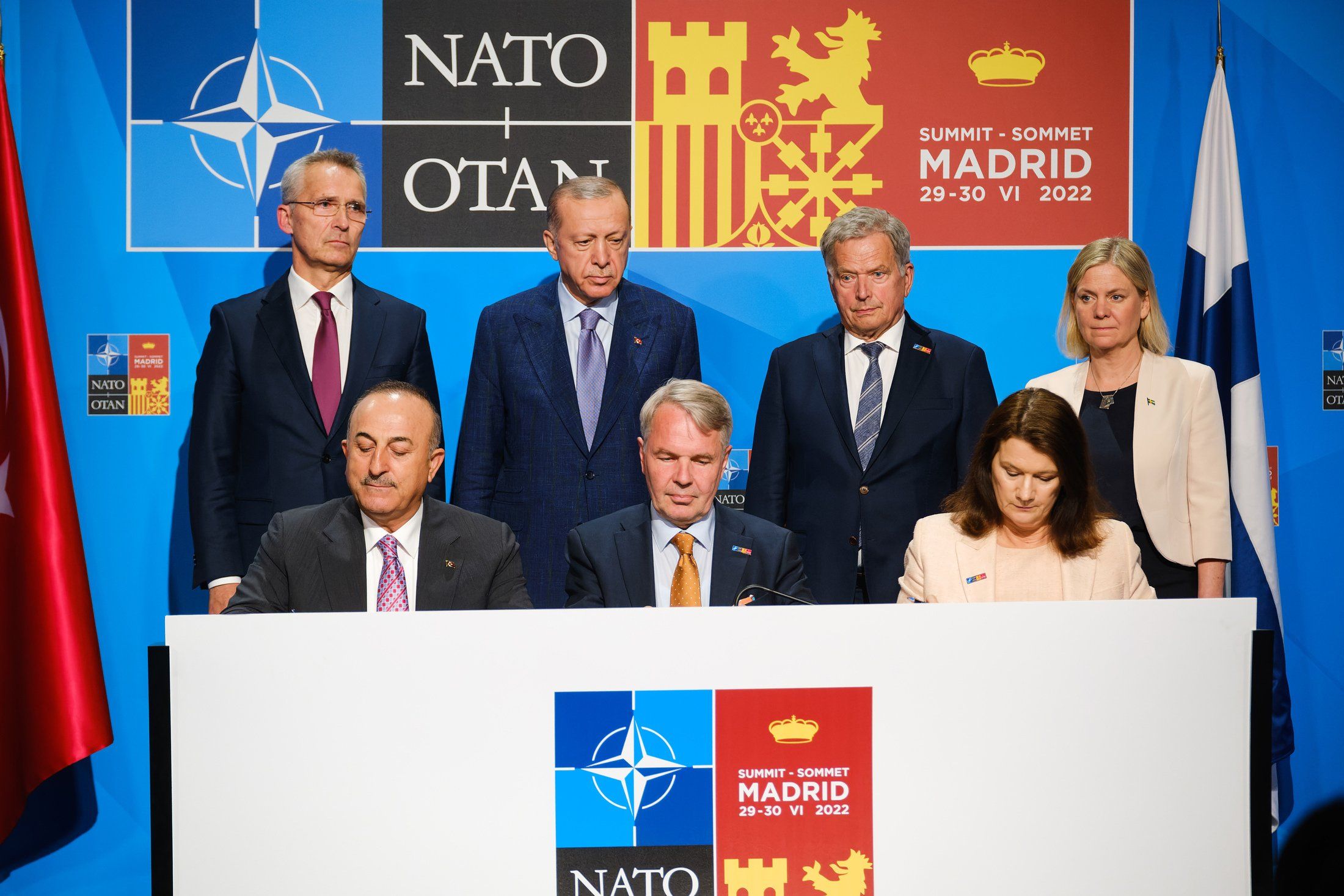 ​(Back L-R) NATO Secretary General Jens Stoltenberg, Turkish President Recep Tayyip Erdogan, Finnish President Sauli Niinisto, Swedish PM Magdalena Andersson look at the signing a defense memorandum by (Front L-R) their countries' respective foreign ministers.