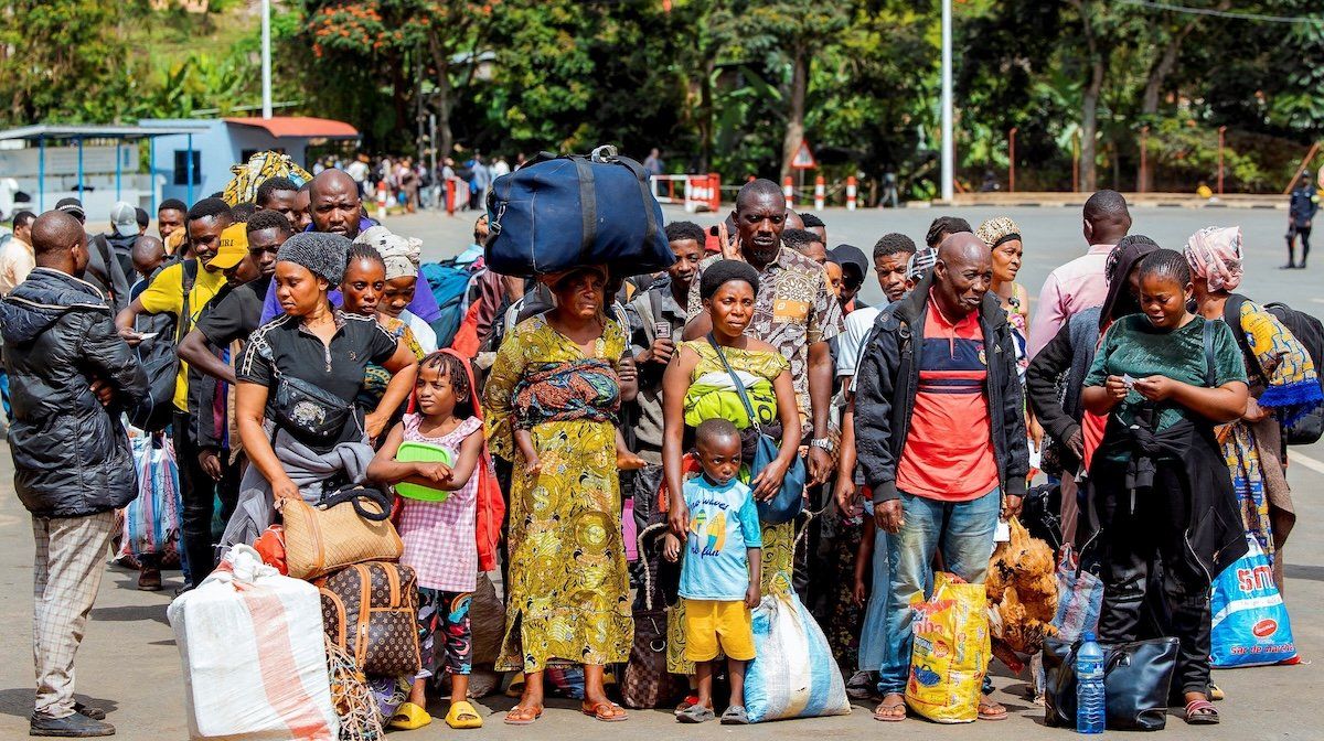 ​Congolese civilians who fled from Bukavu, eastern Democratic Republic of Congo, following clashes between M23 rebels and the Armed Forces of the Democratic Republic of the Congo, carry their belongings as they gather at the Rusizi border crossing point to return home, in Rusizi district, Rwanda, on Feb. 17, 2025. 