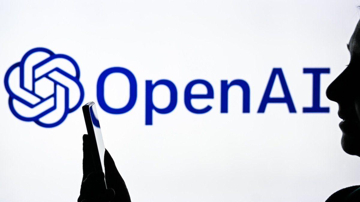 EDMONTON, CANADA - APRIL 20: An image of a woman holding a cell phone in front of a OpenAI logo displayed on a computer screen, on April 20, 2024, in Edmonton, Canada. 