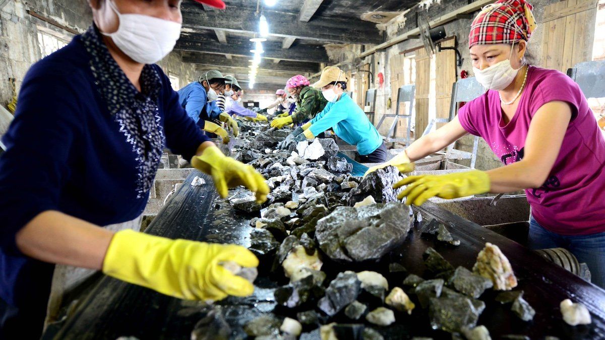 --FILE--Chinese workers check tungsten ore at a factory