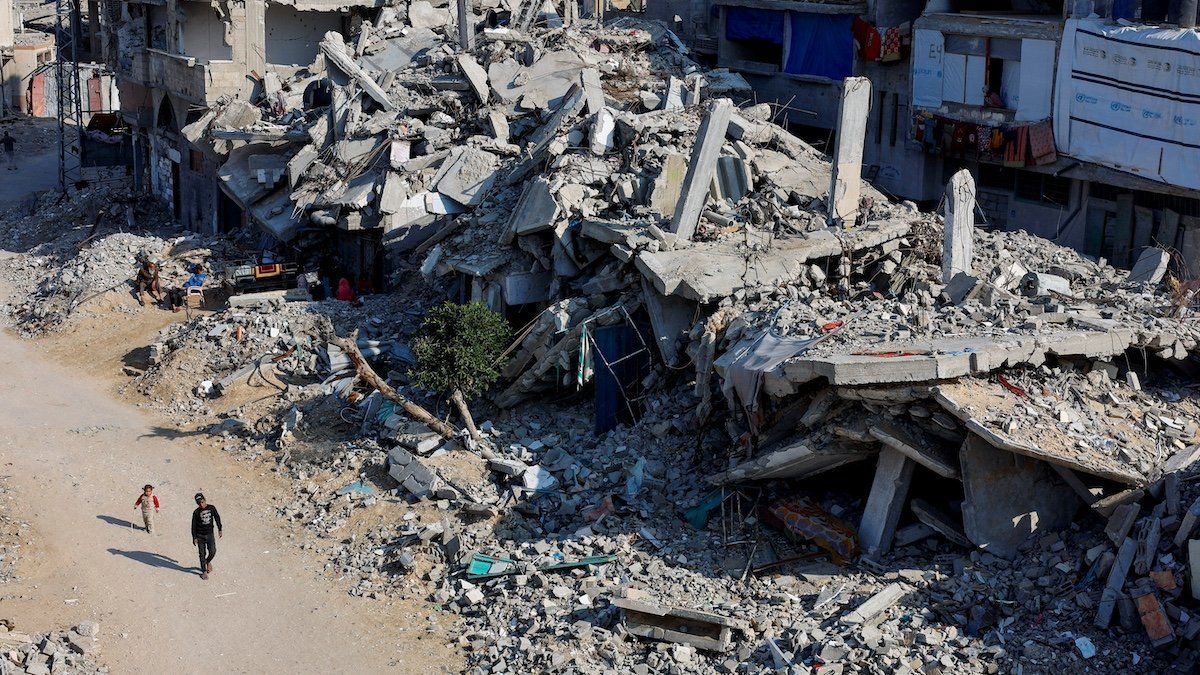 ​FILE PHOTO: Palestinian children walk past the rubble of houses, destroyed in previous Israeli strikes, amid the Israel-Hamas conflict, in Khan Younis, southern Gaza Strip, January 7, 2025.