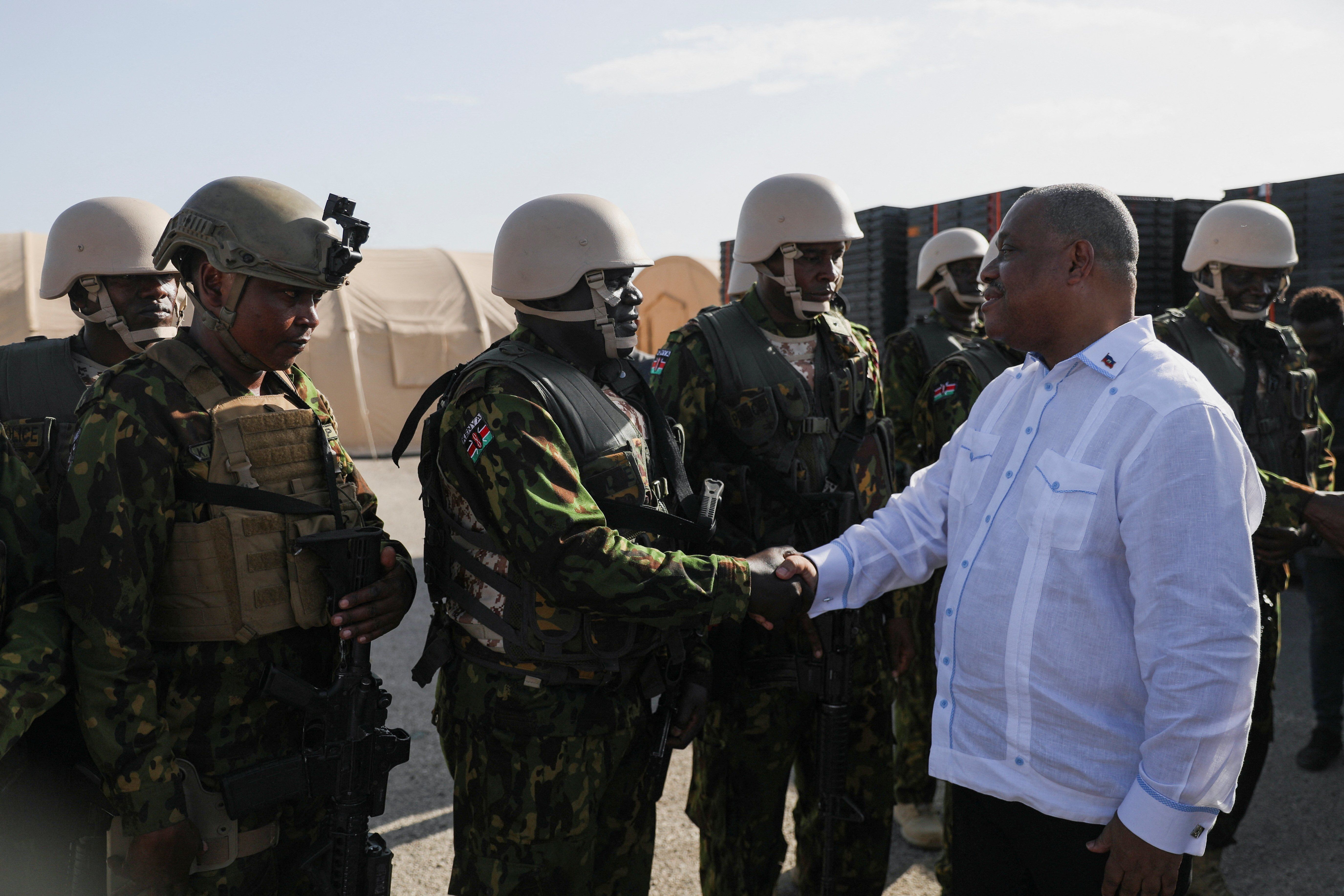 ​Haiti's Prime Minister Garry Conille shakes hands with members of the first contingent of Kenyan police as part of a peacekeeping mission in the Caribbean country, in Port-au-Prince, Haiti June 26, 2024.