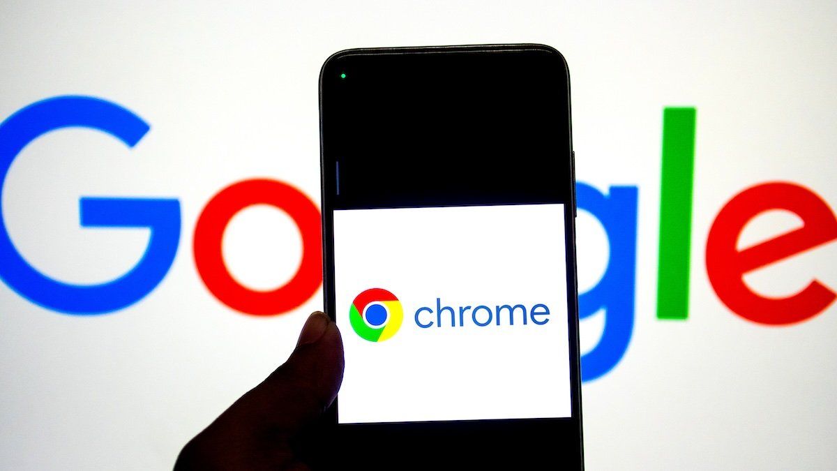 In this photo illustration, a Google Chrome logo seen displayed on a smartphone with a Google Logo in the background.