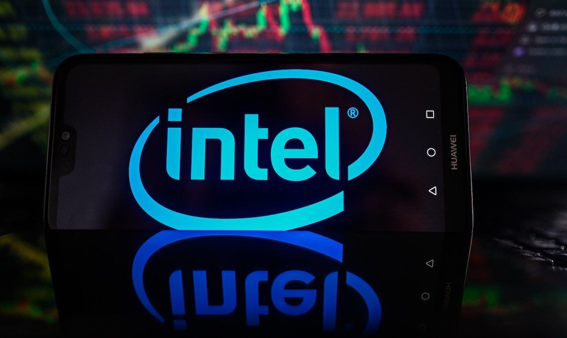 ​In this photo illustration, Intel logo is displayed on a smartphone with stock market percentages on the background. 