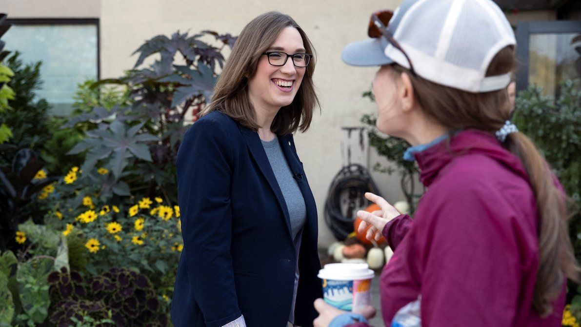 ​Sarah McBride, Delaware state senator and candidate for United States Representative, speaks to a voter outside of a coffee shop in Wilmington, Delaware, on Oct. 26, 2024. 