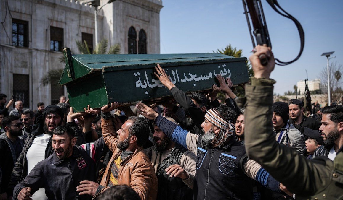 ​Syrian fighters and civilians carry the coffin of a member of the Syrian security forces during his funeral in Hama province after he and 11 other colleagues were killed in an ambush by groups loyal to the ousted President Bashar al-Assad in Latakia. 