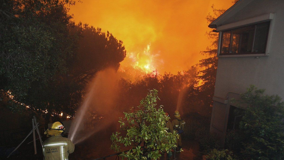 ​Los Angeles City firemen spray water to protect houses threatened by a brush fire in Griffith Park, Los Angeles May 8, 2007. The fire broke out in the hills above Los Angeles forcing evacuation of the city's largest park and zoo. Local media reported that authorities have arrested an arson suspect who was badly burned. 