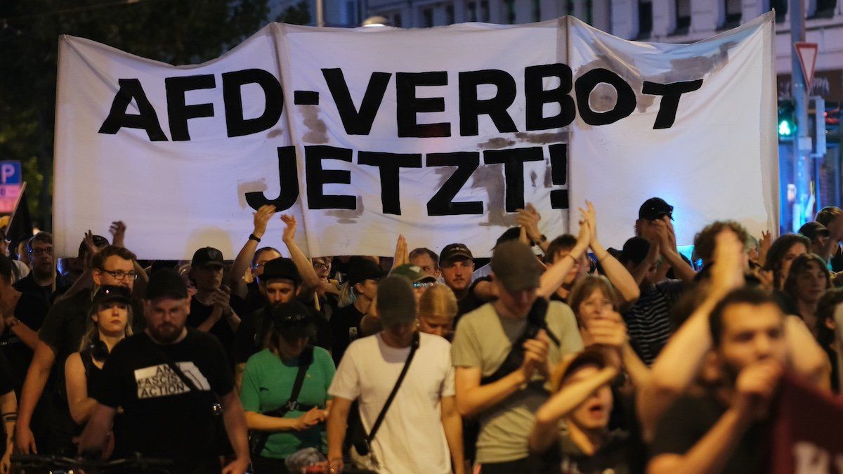 Participants in a left-wing demonstration walk along a street with a banner reading "AfD ban now!". Several hundred people protest against the AfD's performance in the state elections in Saxony.