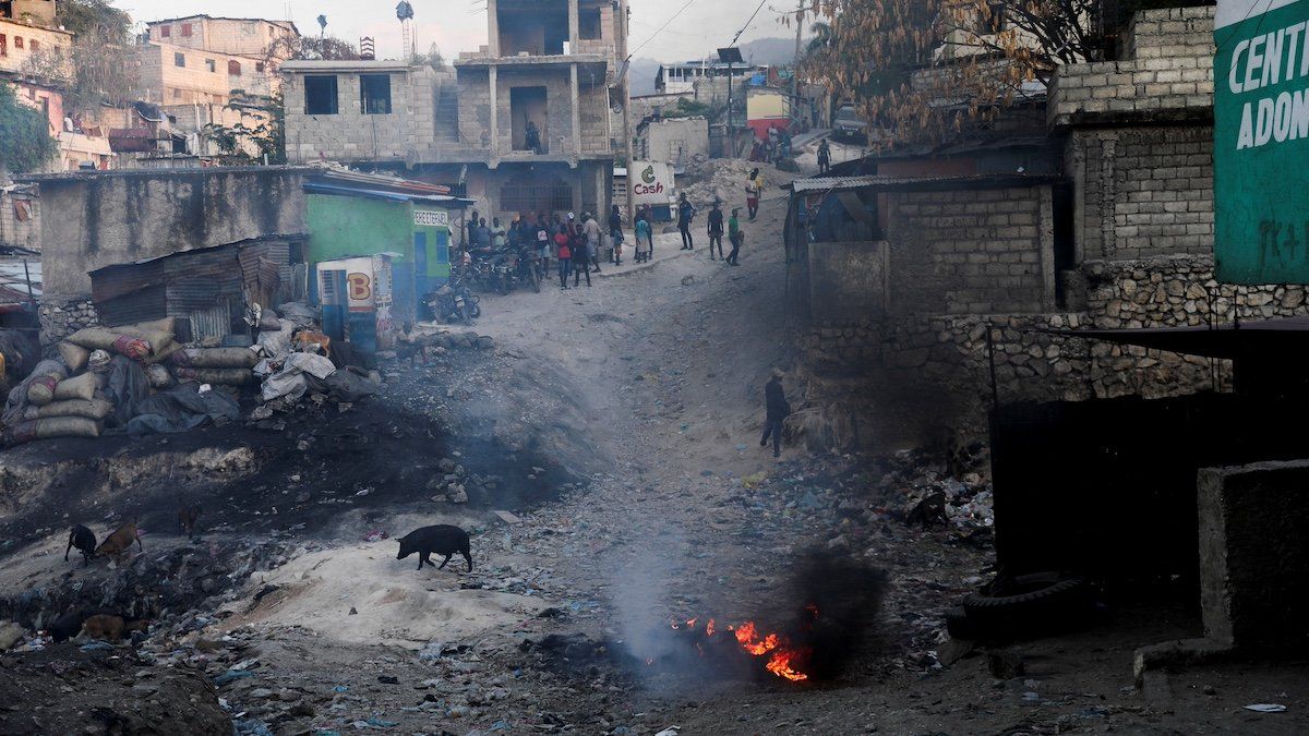 ​People gather as they watch from afar after an alleged gang member was killed and set on fire, amid an escalation in gang violence, in Port-au-Prince, Haiti March 20, 2024. 