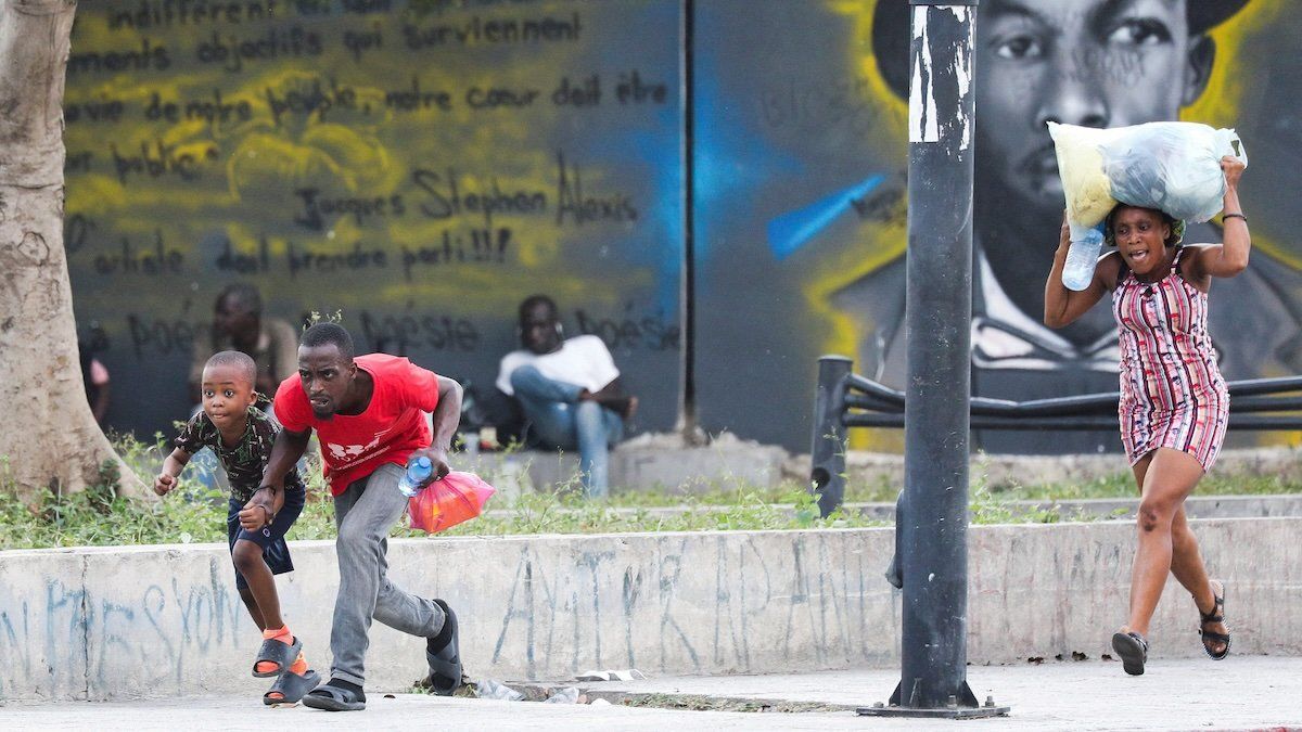 People take cover from gunfire near the National Palace, in Port-au-Prince, Haiti March 21, 2024. 