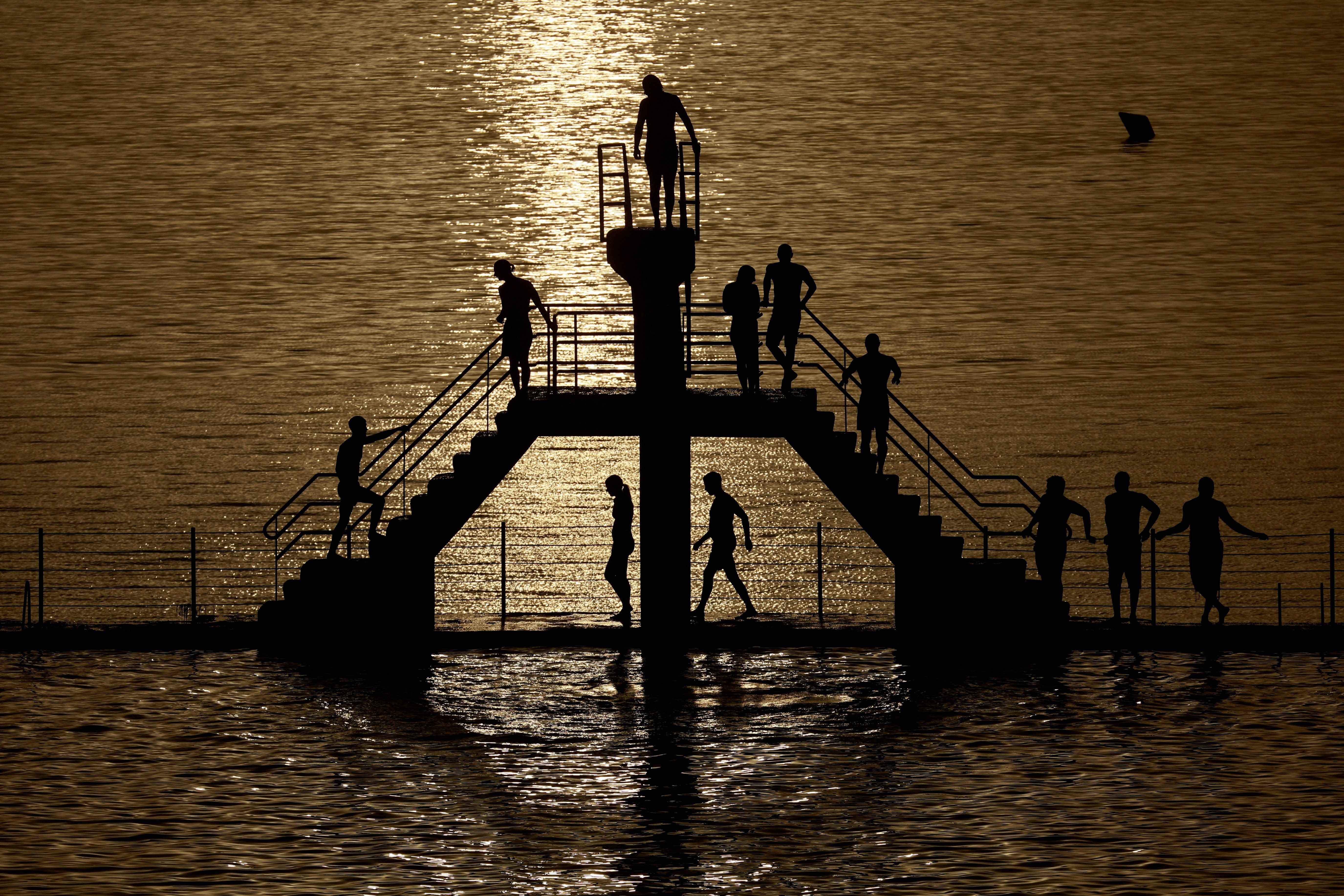 People wait to dive at the "bon secours" beach, as a heatwave hits France.