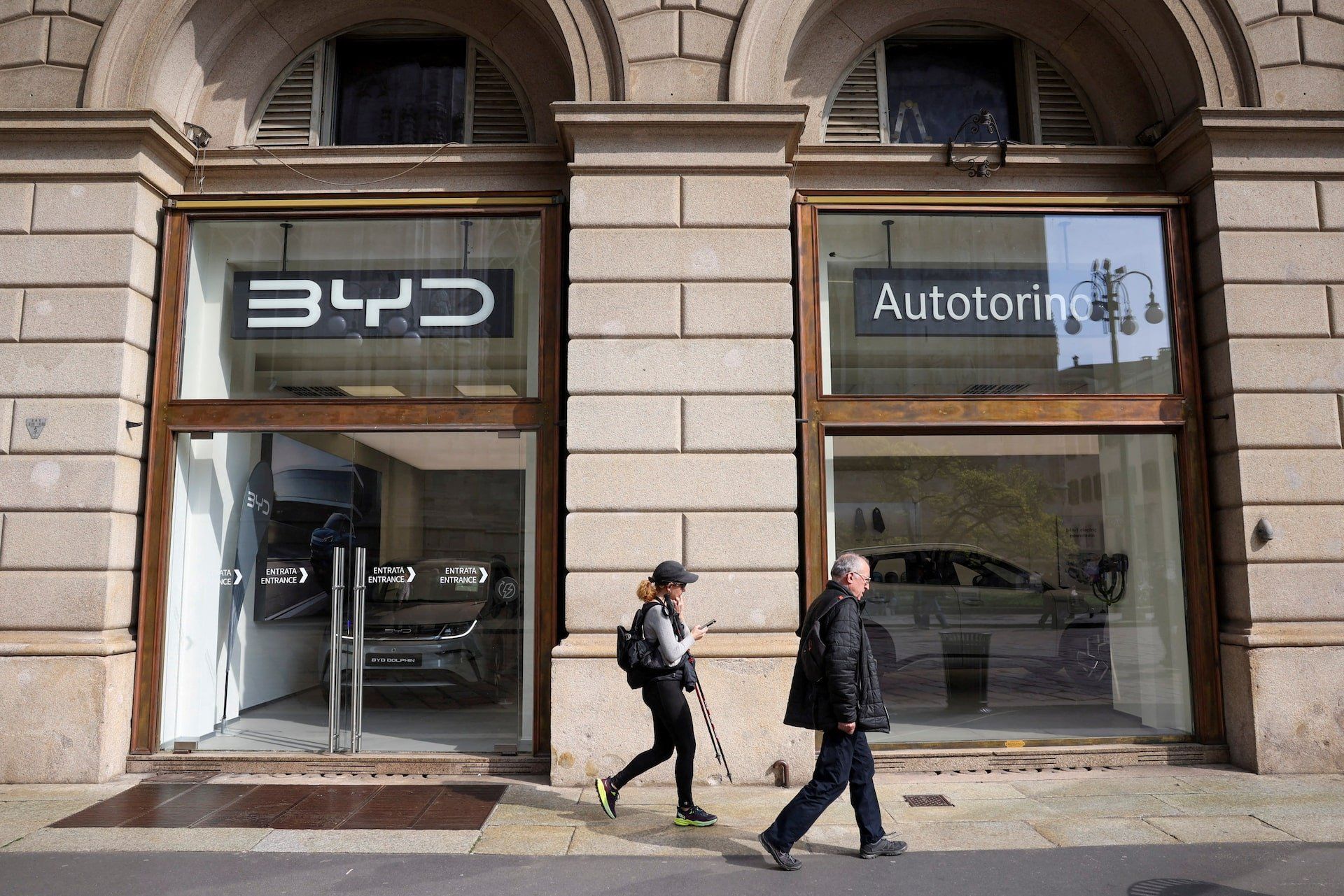 People walk in front of BYD Auto company and Autotorino store in Milan, Italy, March 20, 2024. 