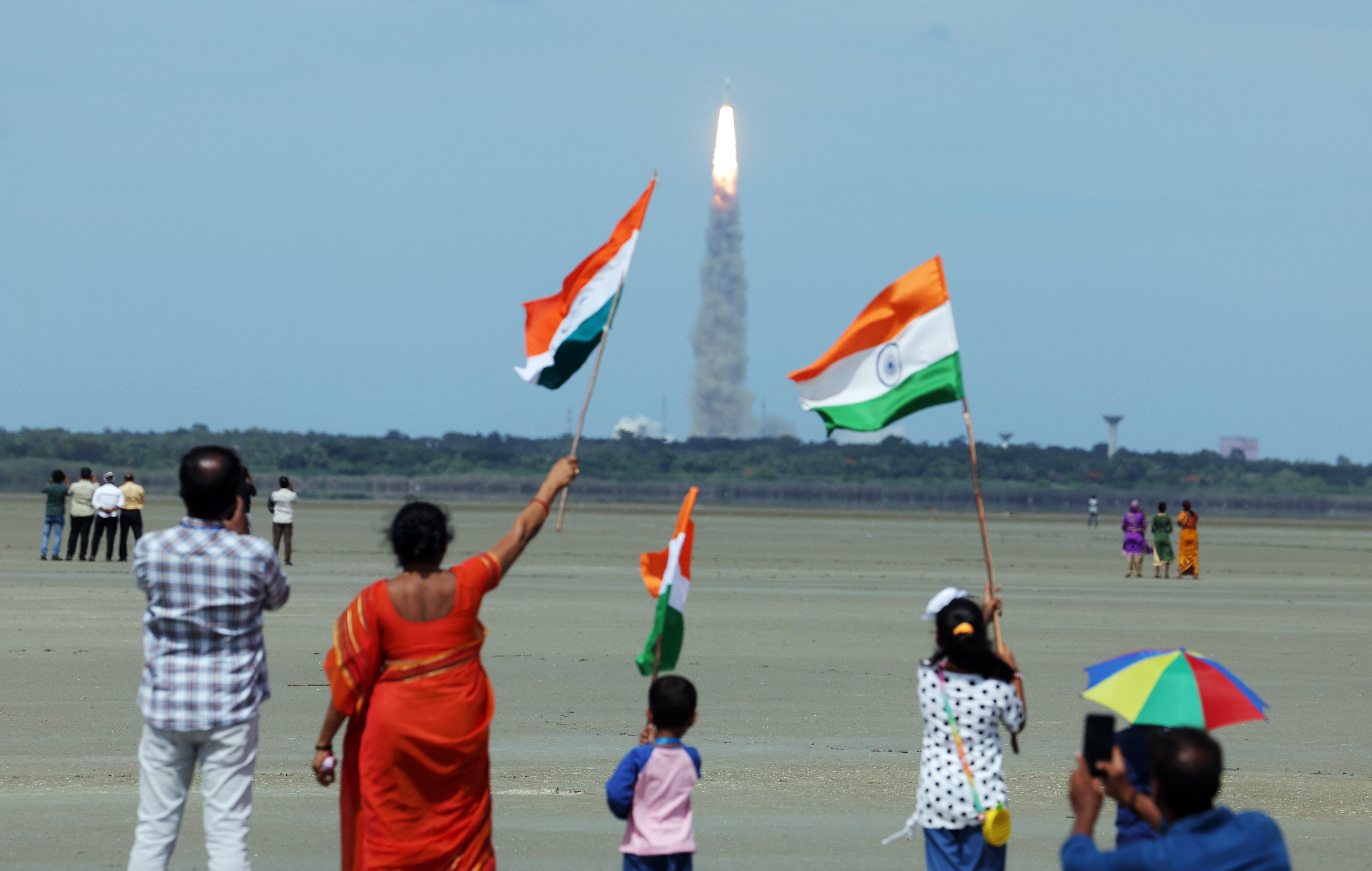 People wave India's flag as they celebrate the launch of Chandrayaan-3 mission from the Satish Dhawan Space Centre in Sriharikota.